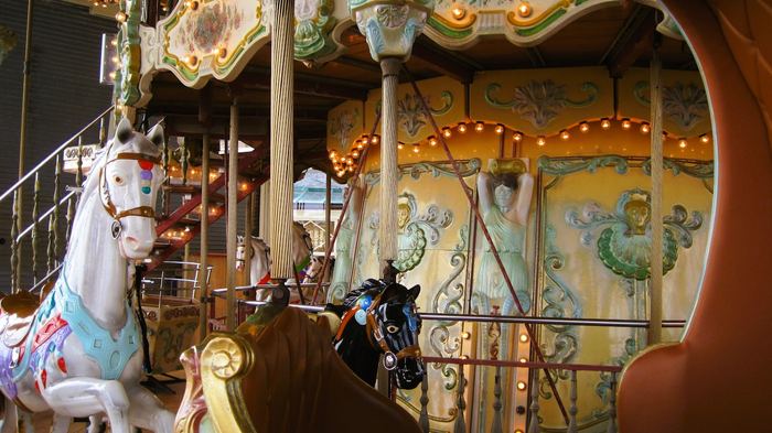 A traditional painted carousel with horses and lights